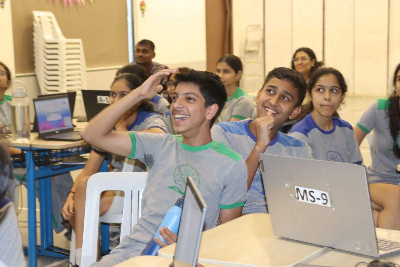A student laughing with his hand on his head