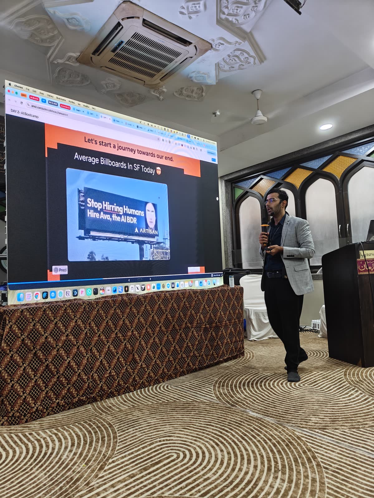 Ali presenting beside a large screen in Kurla