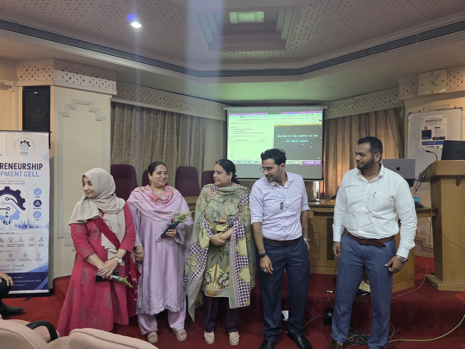 Ali with EDC faculty coordinators in front of the session screen