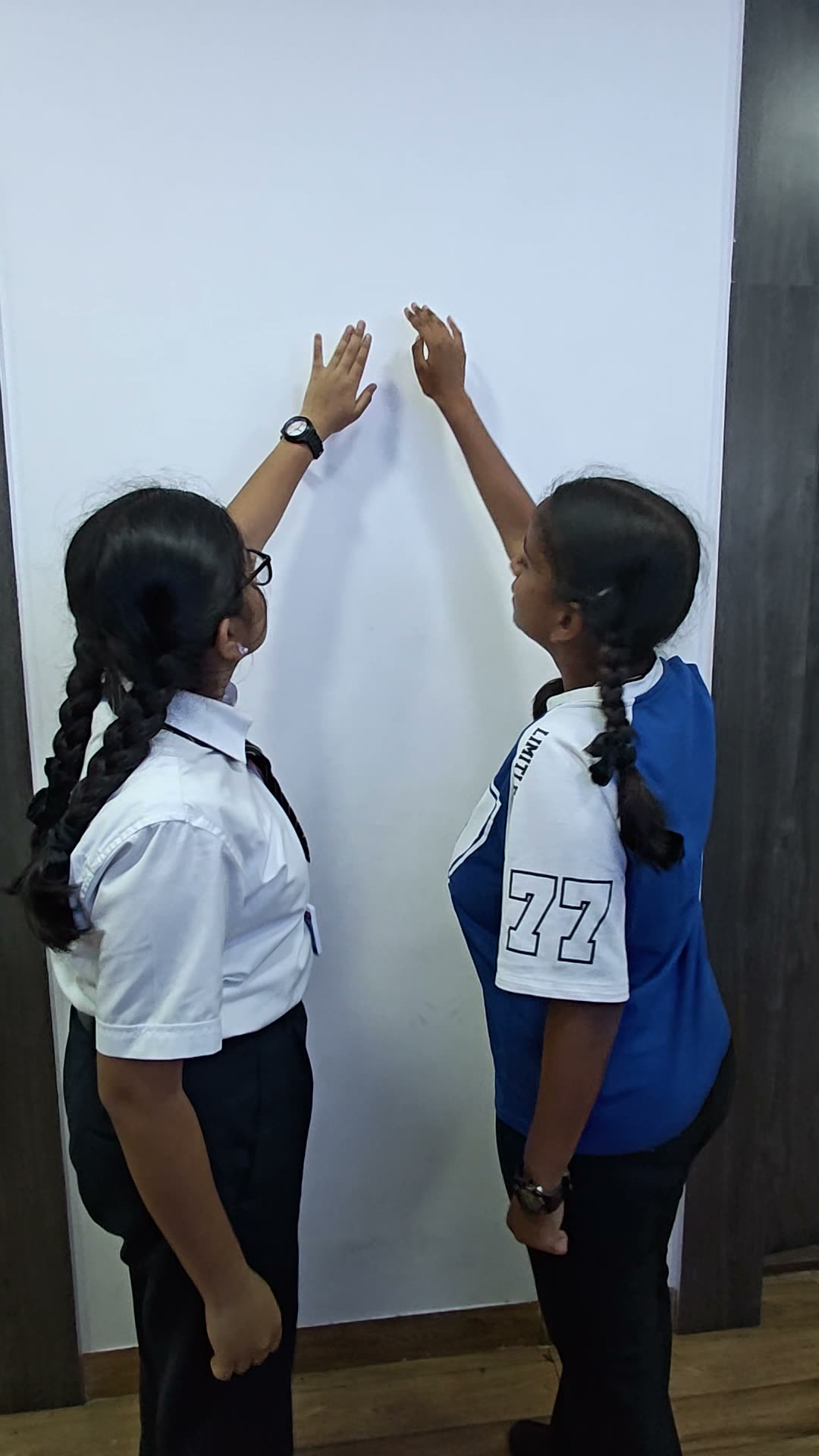 Two students adding sticky notes to the idea wall