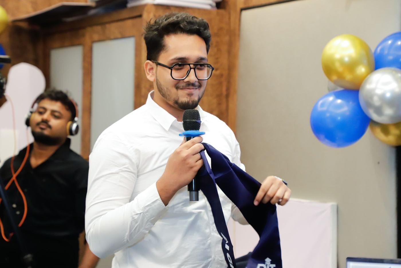 A graduate presenting with a big smile