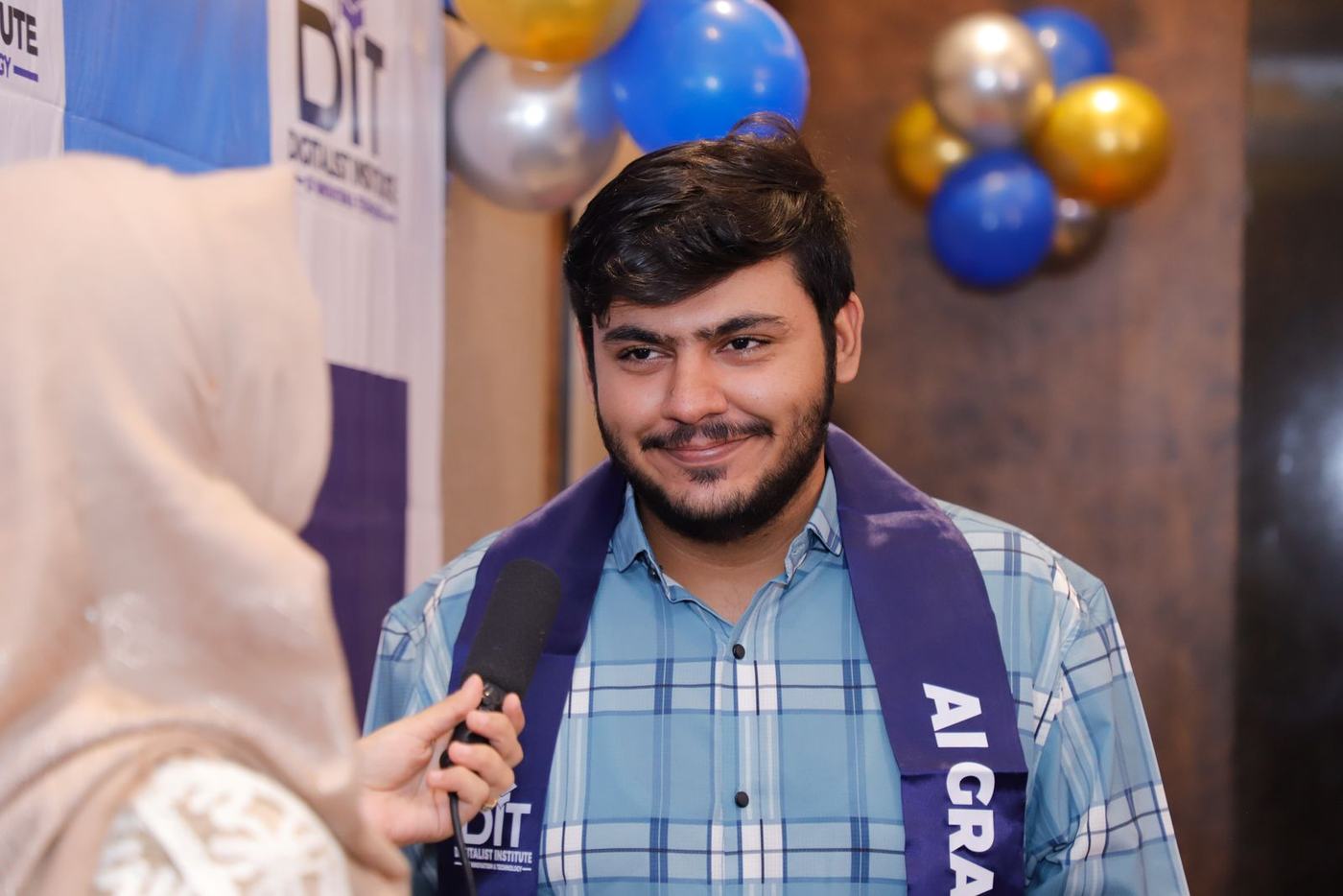 A graduate smiling during his red-carpet interview