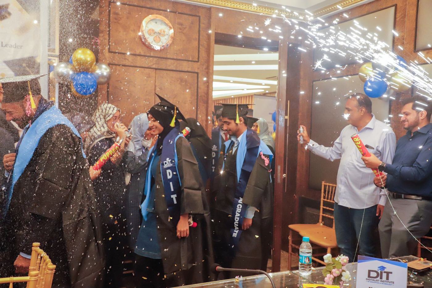 Sparklers fountain over cheering graduates